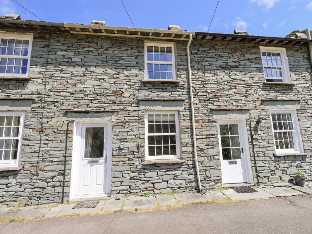 a stone building with white doors and windows at Slaters Rest in Chapel Stile