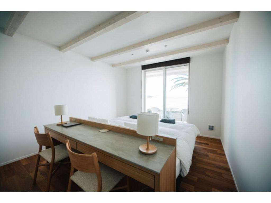 1 dormitorio con escritorio, 1 cama y ventana en Colorit Goto Islands - Vacation STAY 61529v, en Goto