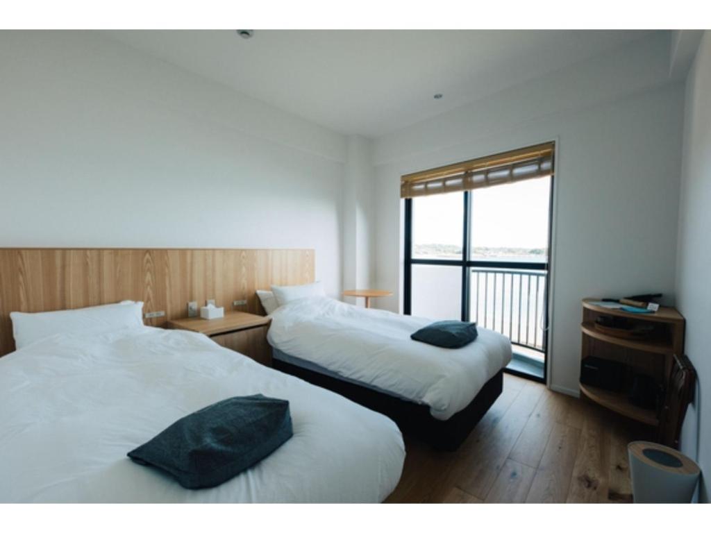 a hotel room with two beds and a balcony at Colorit Goto Islands - Vacation STAY 61527v in Goto