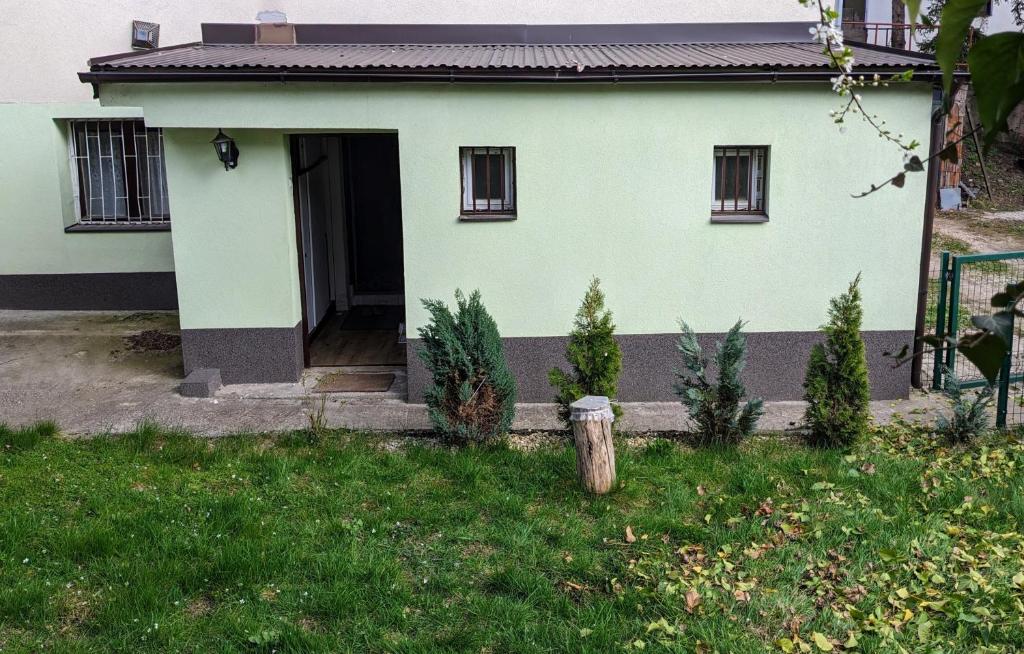 una casa blanca con una puerta en el césped en Green apartment Sarajevo, en Sarajevo
