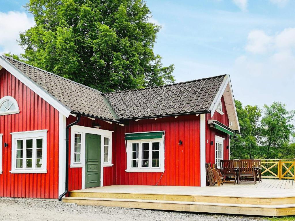 a red shed with a white roof and a patio at Holiday home ALLINGSÅS, SVERIGE II in Hjälmared