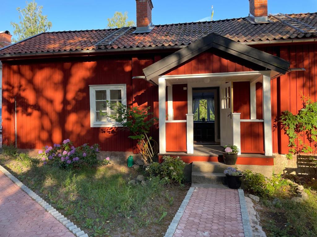 ein rotes Haus mit einem Weg zur Eingangstür in der Unterkunft Bagarstugan in Kolbäck