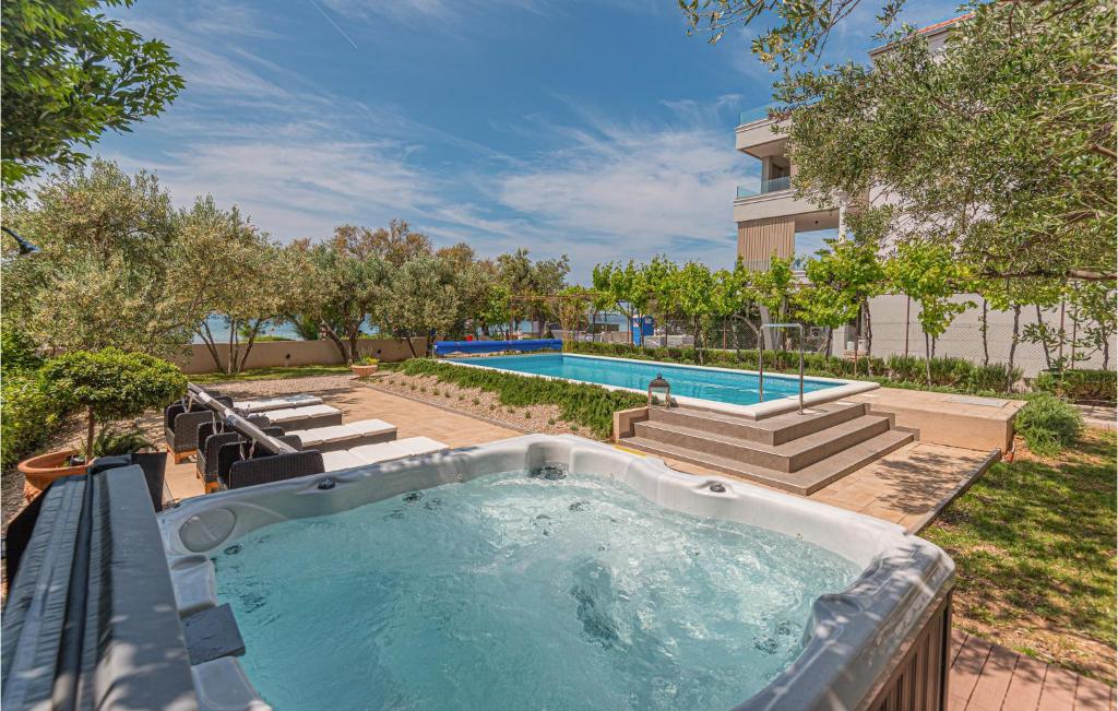 einen Whirlpool im Garten neben einem Pool in der Unterkunft Beach Front Home In Srima in Srima