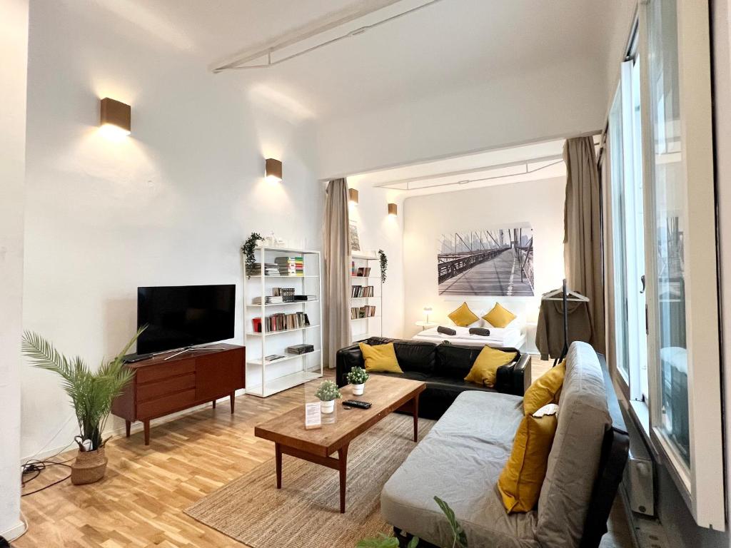 a living room with a couch and a tv at Große Loft-Apartments im Herzen Bremens in Bremen