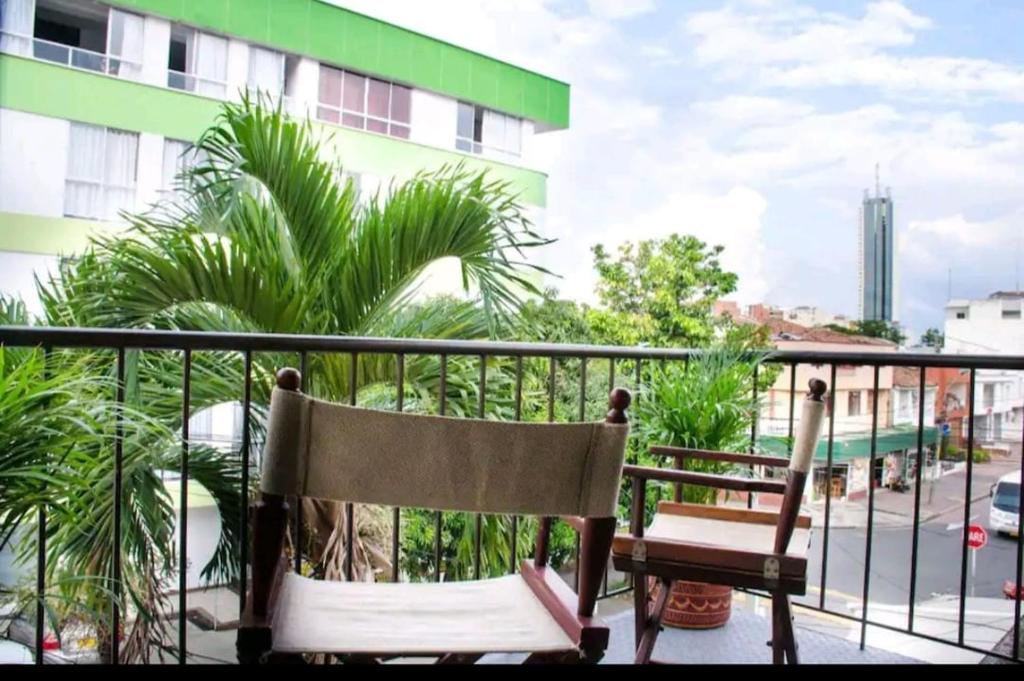 einen Balkon mit einem Stuhl und einer Pflanze in der Unterkunft Apartamento Granada 2 habitaciones - 201 in Cali