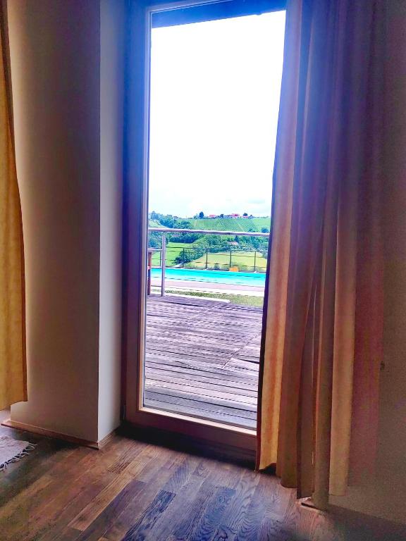 an open door with a view of a wooden deck at Turistična kmetija HLEBEC in Kog