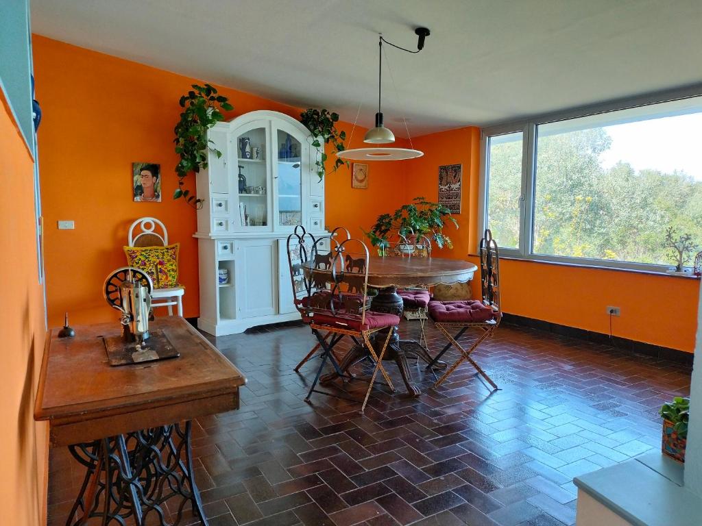 a dining room with orange walls and a table and chairs at le finestre sul mare in Conversano