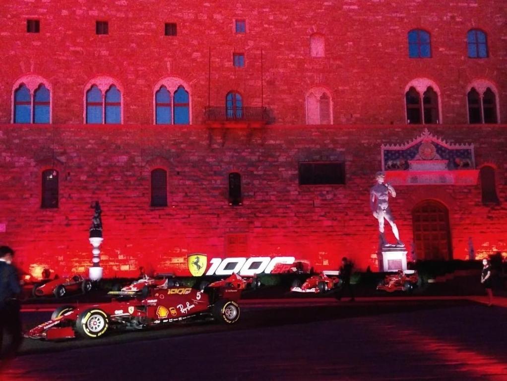 een rood gebouw met auto's ervoor geparkeerd bij Firenze F1 in Florence