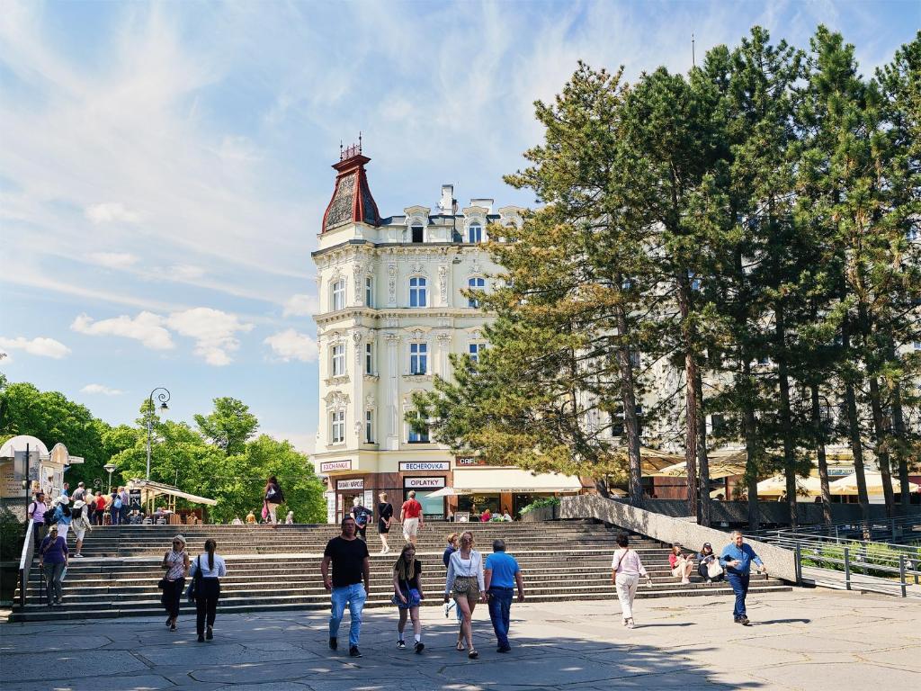 un grupo de personas caminando por las escaleras frente a un edificio en IMPERIAL Apartments en Karlovy Vary