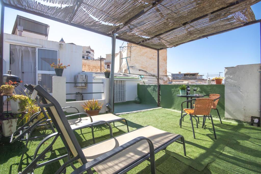 Un patio con sillas y una mesa en el balcón. en La Casa Del Abuelo, en Vélez-Málaga