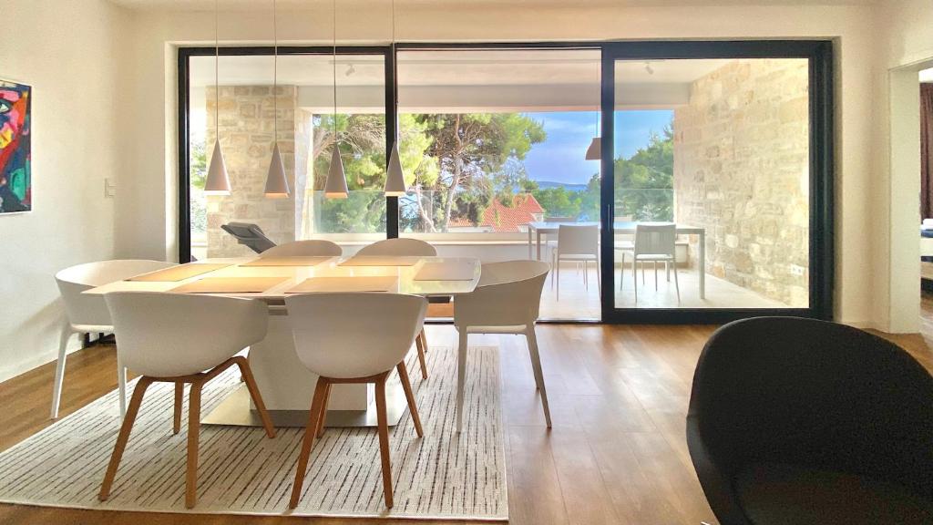 a dining room with a table and chairs and a room with a view at Nautilus-Bay Suites - Dreizimmer Suite 420 in Zavala