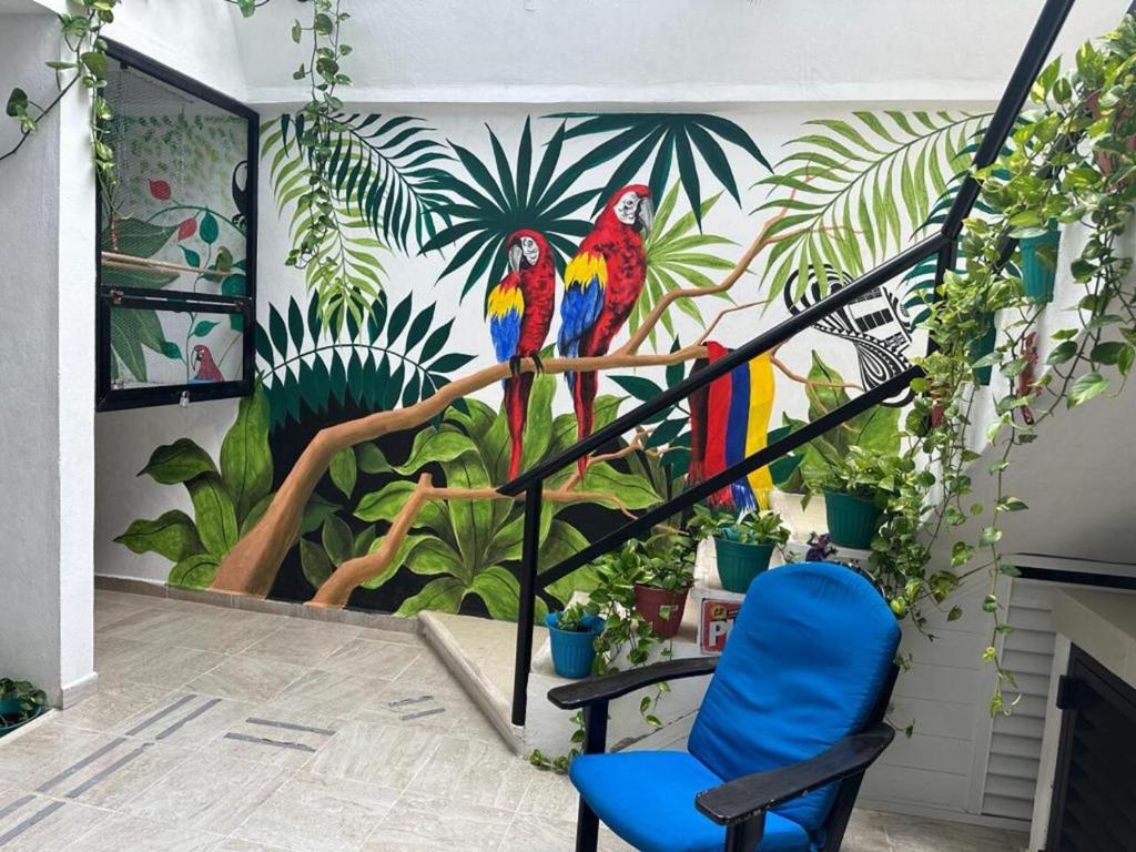 a staircase with a mural of parrots on a wall at LUX Studio ROOM LAS PALMAS PUERTO MORELOS in Puerto Morelos