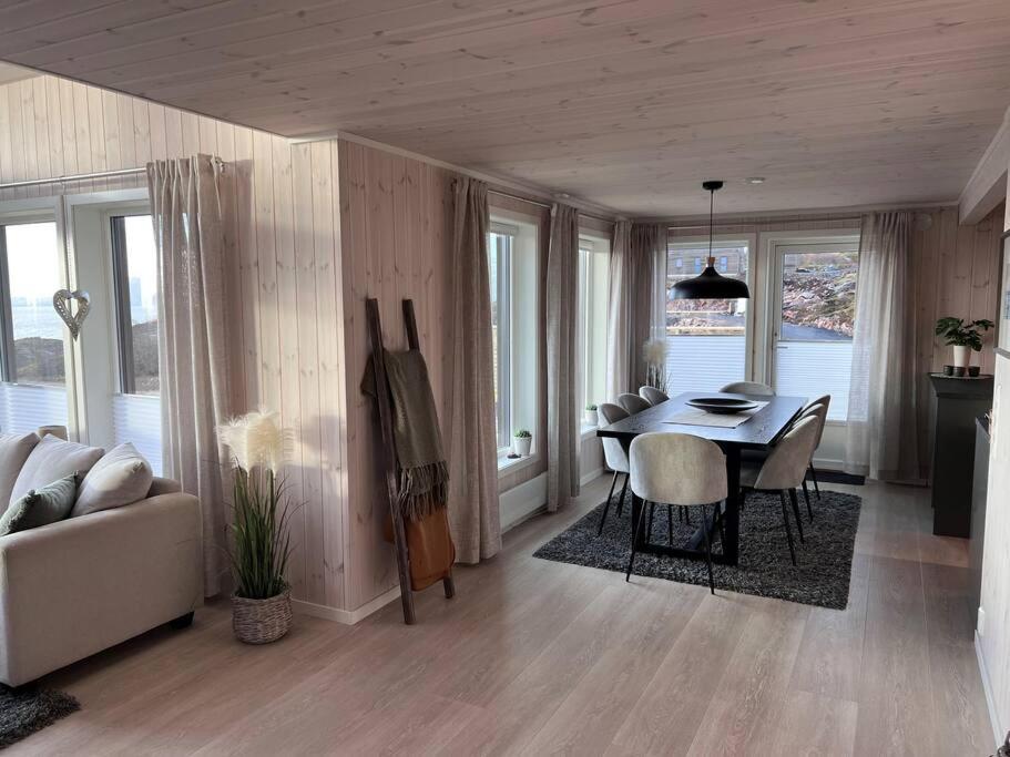 a living room with a table and chairs and a couch at Sea & Sky Vestfjord Panorama in Lødingen