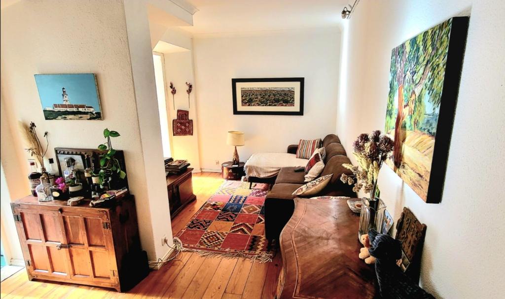 Cosy Apartment in Central Lisbon في لشبونة: غرفة معيشة مع أريكة وغرفة نوم
