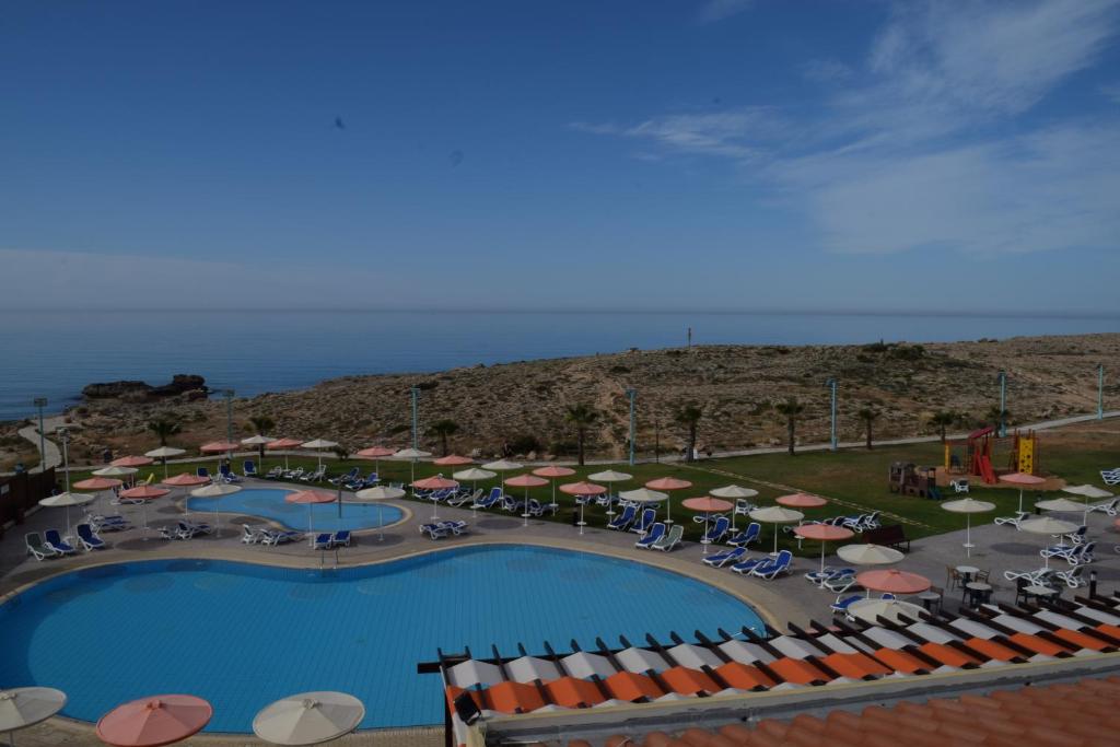 an overhead view of a pool with umbrellas and chairs at Aktea Beach Village in Ayia Napa