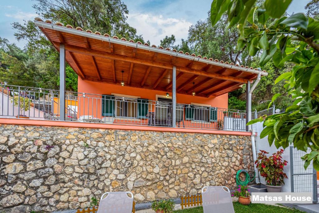 パレオカストリッツアにあるMatsas House & Studioの石壁と木屋根のオレンジ色の家