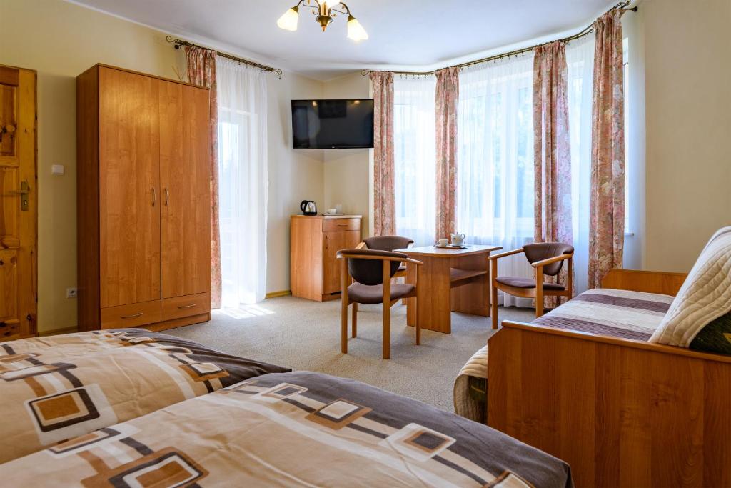ヤストシェンビャ・グラにあるWilla Agawaのベッド2台、テーブルと椅子が備わるホテルルームです。