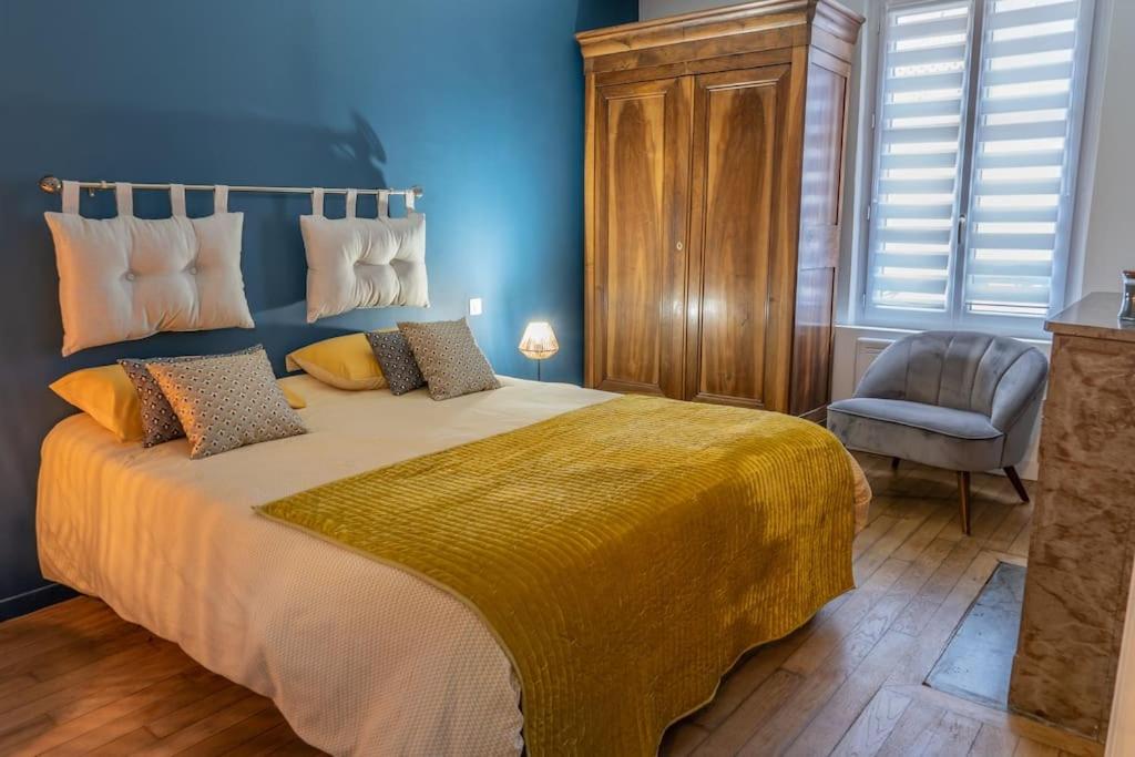 une chambre avec un grand lit et une chaise dans l'établissement Chartres hyper centre bel appartement rénové, à Chartres