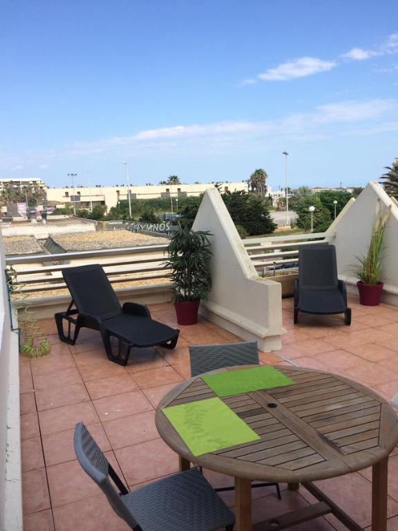 um pátio com cadeiras e uma mesa no telhado em Cap d'Agde Naturiste F em Cap d'Agde