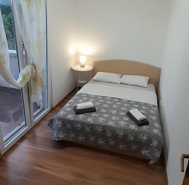 a bedroom with a bed and a large window at Apartments Zvonimir,place by the sea in Mirce