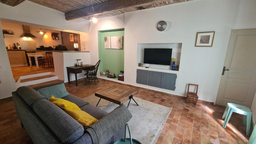 a living room with a couch and a tv at Cocon du Papillon à Lourmarin in Lourmarin