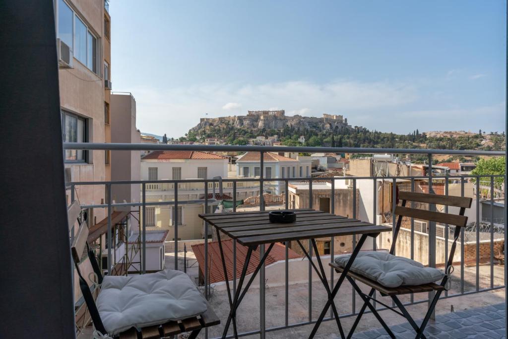 une table et des chaises sur un balcon avec vue dans l'établissement Luxury apartment overlooking the citadel of Tsakas, à Athènes