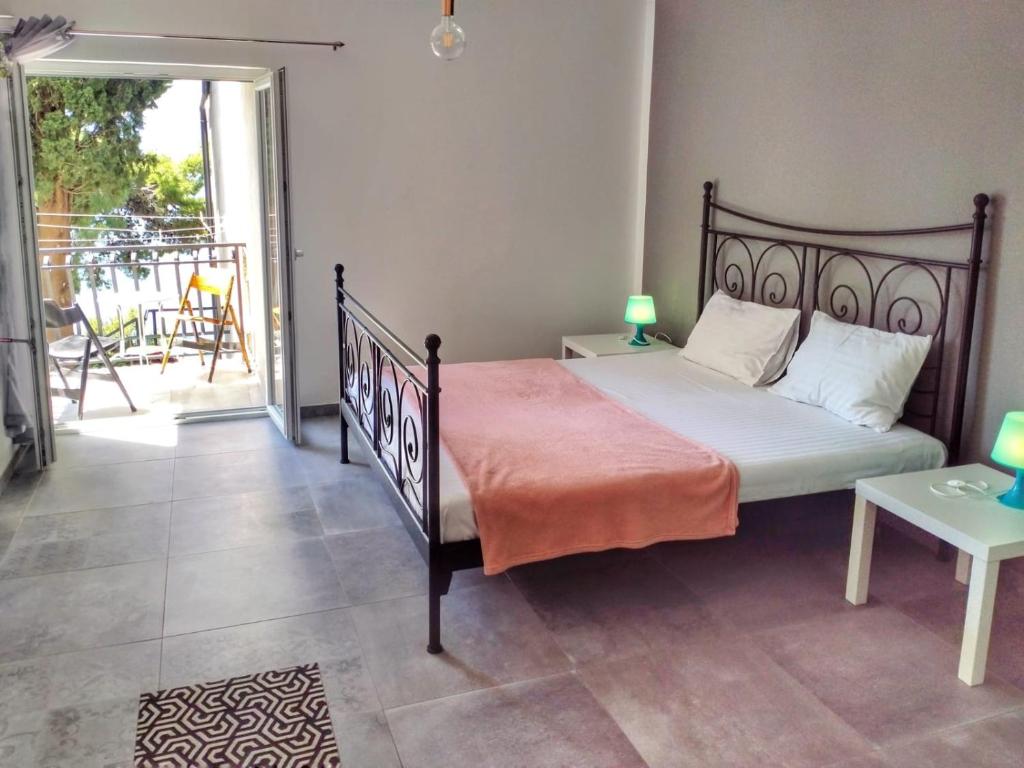 a bedroom with a bed and a balcony with a table at Minimalistic Oasis by the Sea in Stanici in Celina