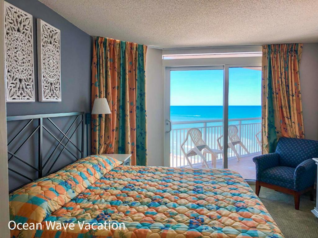 a bedroom with a bed and a balcony with the ocean at Pristine Condo Glorious Ocean View HS 11th Floor in Myrtle Beach