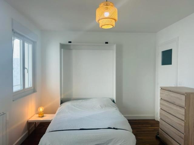 een slaapkamer met een bed, een bureau en een raam bij studio cosy face à la gare in Lorient