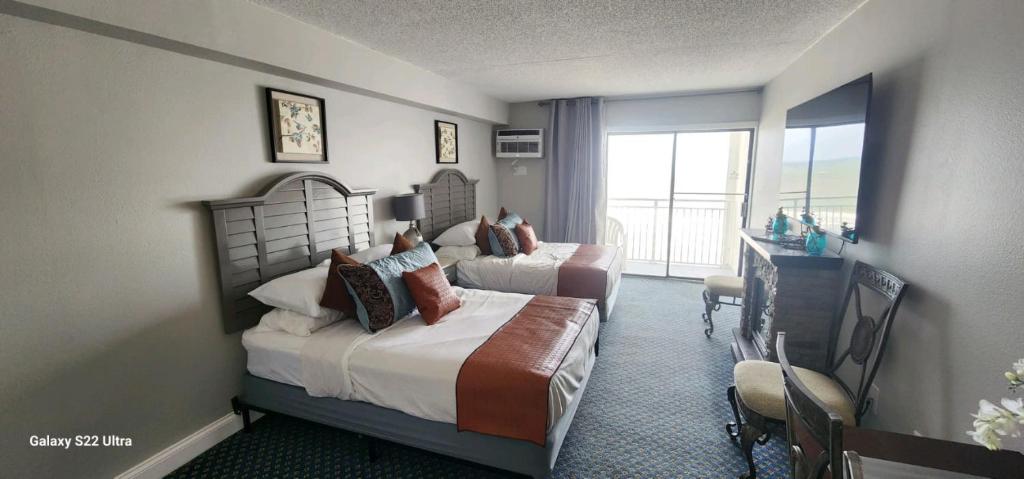 um quarto de hotel com duas camas e uma varanda em Oceanfront Efficiency T508 em Myrtle Beach