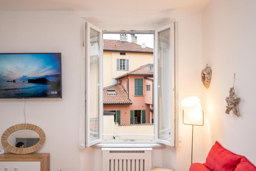 a living room with a window and a tv at PortaTorre Suite, a Charming apartment in the Heart of Como, Free Private Parking, Air Conditioning & More! in Como