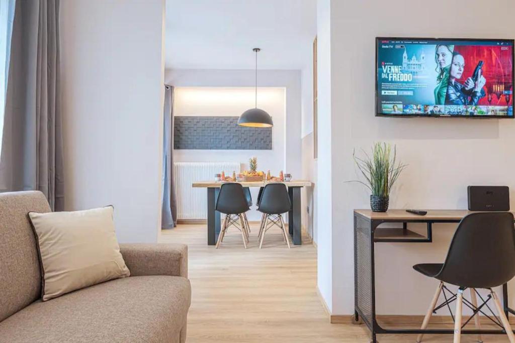 een woonkamer met een bank en een tafel met stoelen bij A 3 minuti dal centro storico In Style Apartment con parcheggio gratuito in Bassano del Grappa