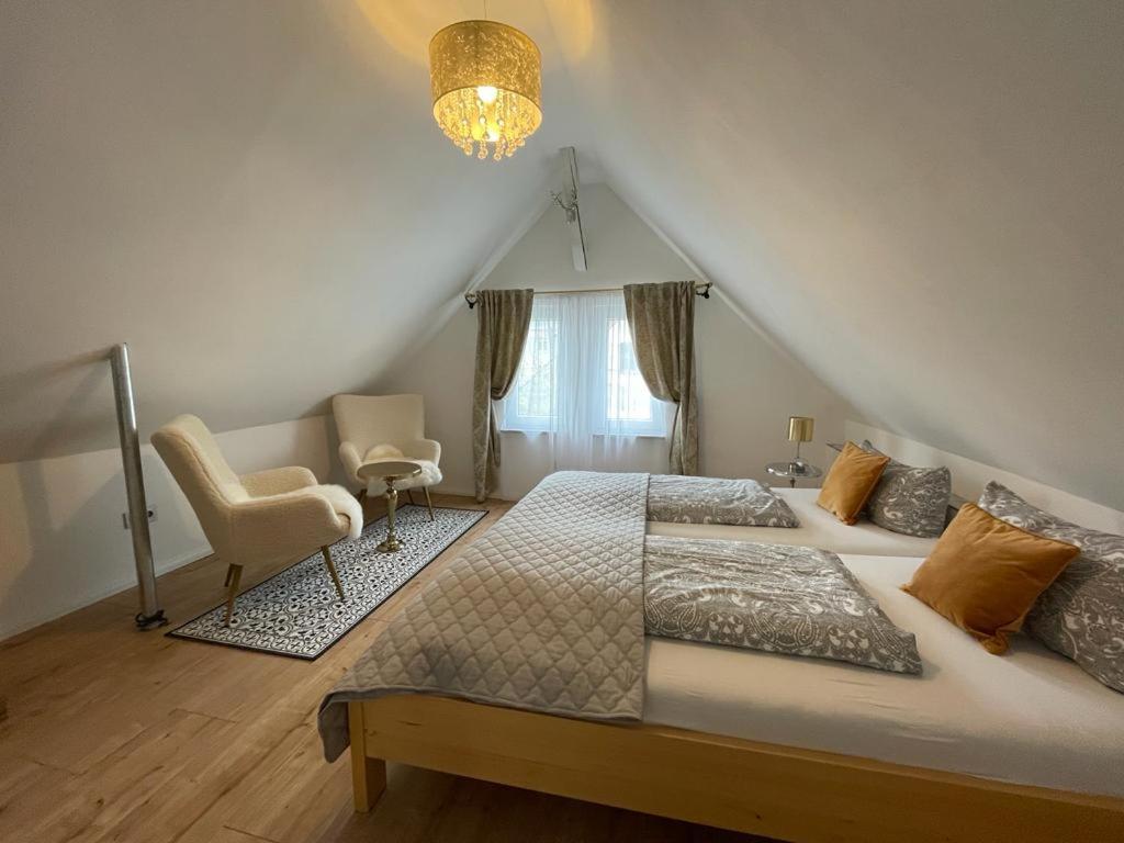 a bedroom with a large bed and a chair at Boutique Haus Sissi in Füssen