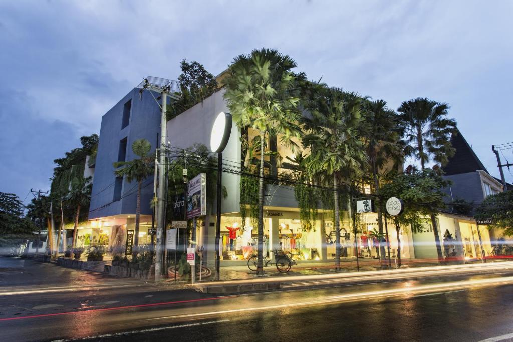 a building with palm trees in front of a street at Petitenget 501 in Seminyak