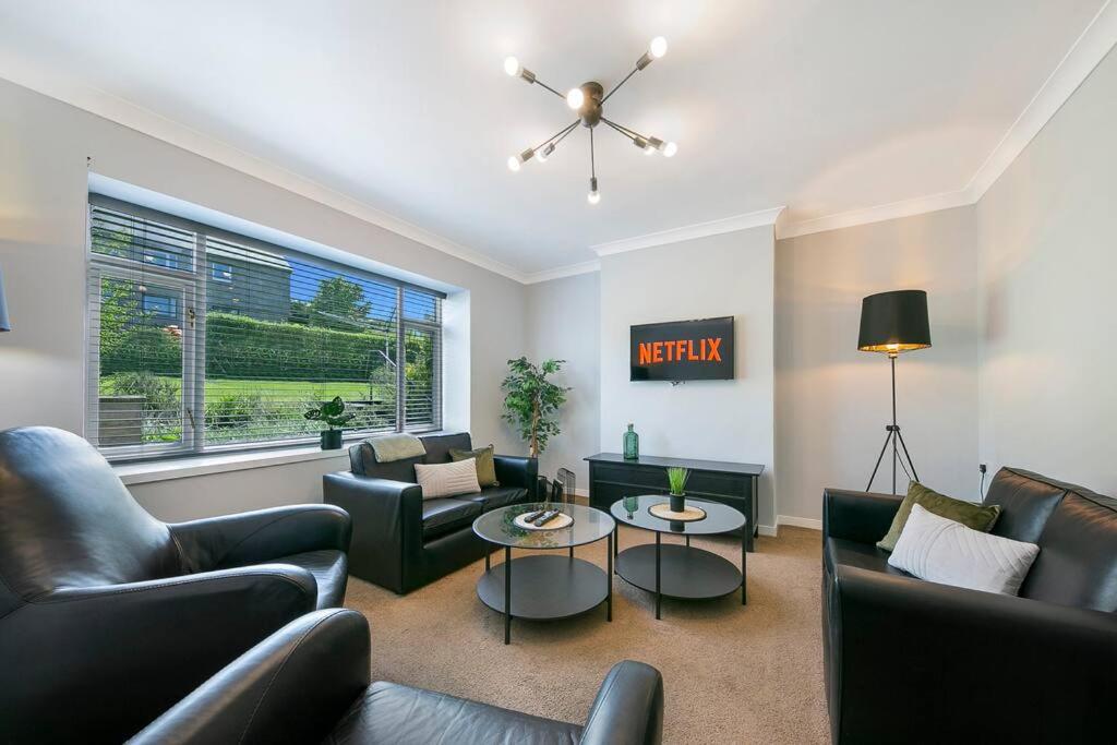 a living room with couches and tables and a window at Faulds Crescent Lodge ✪ Grampian Lettings Ltd in Aberdeen