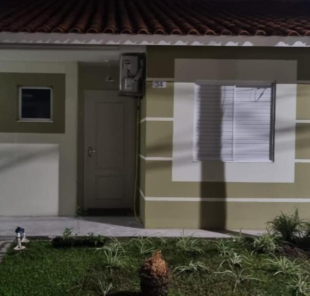 a green and white house with a door and a window at Casa no Moradas in Pelotas