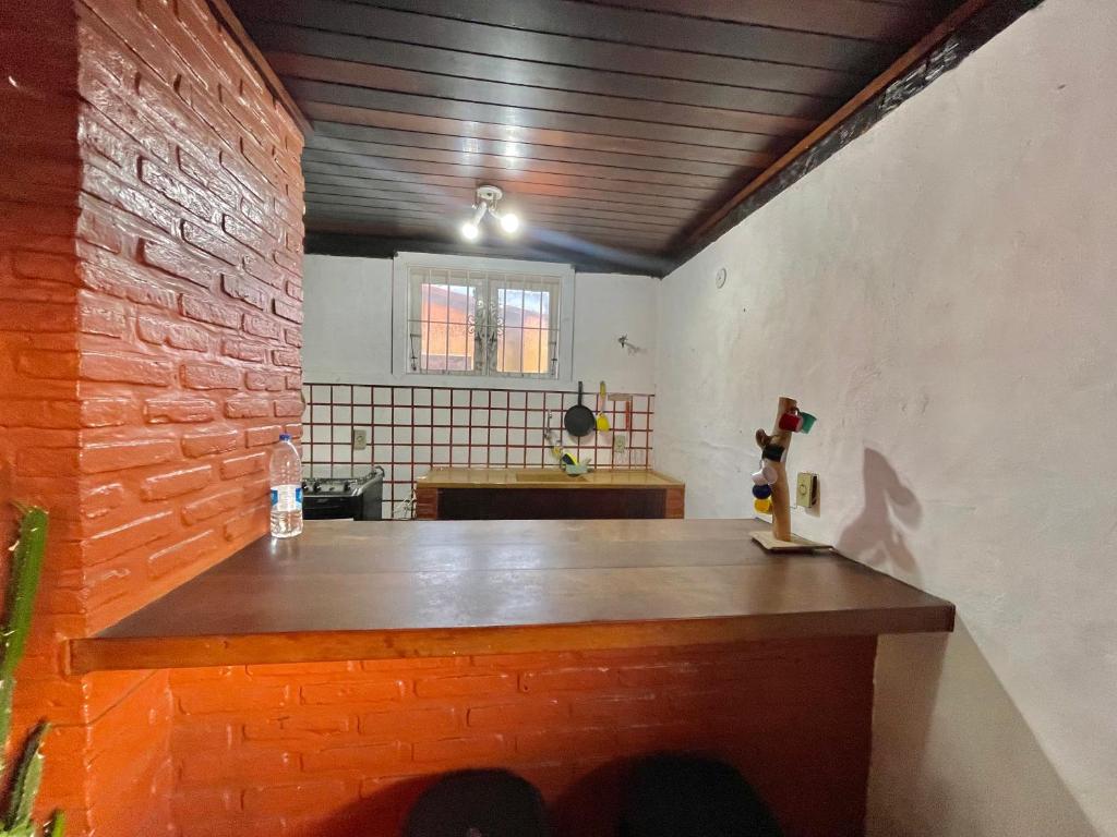 een kamer met een tafel en een bakstenen muur bij Casa praiana in Búzios