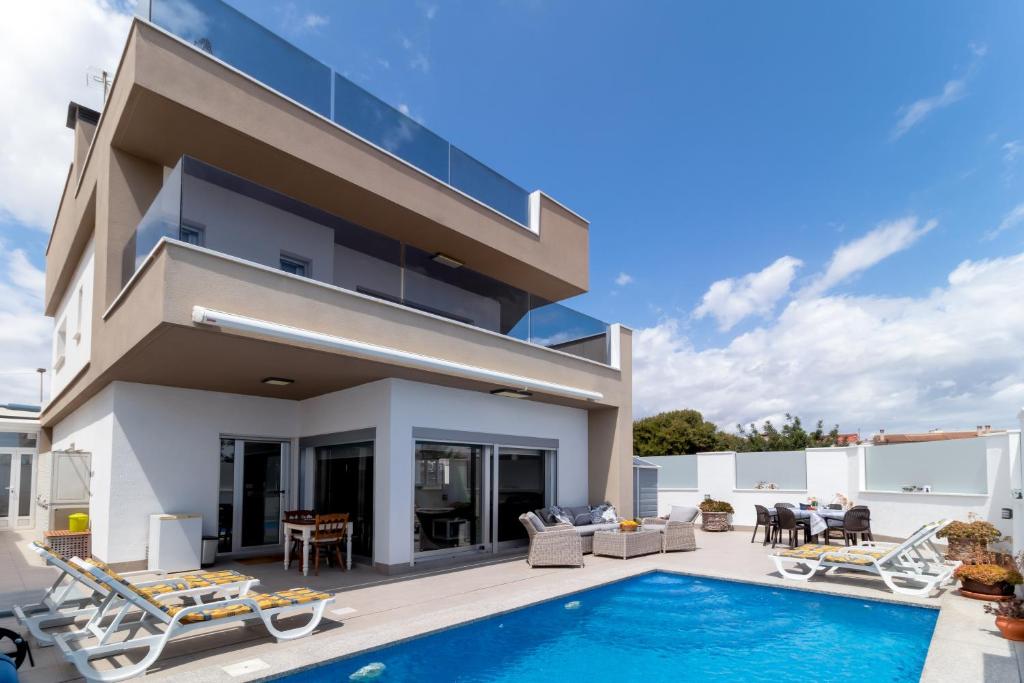 een villa met een zwembad en een huis bij Villa near the sea in Pilar de la Horadada