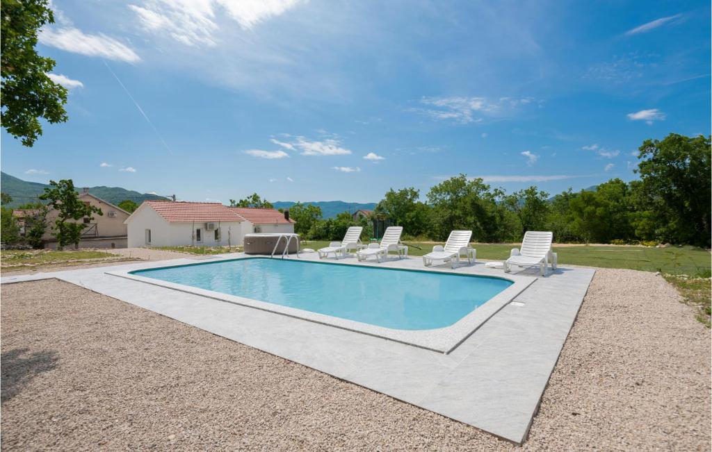 una piscina con sedie a sdraio e una casa di Nice Home In Zavojane With Kitchen a Zavojane