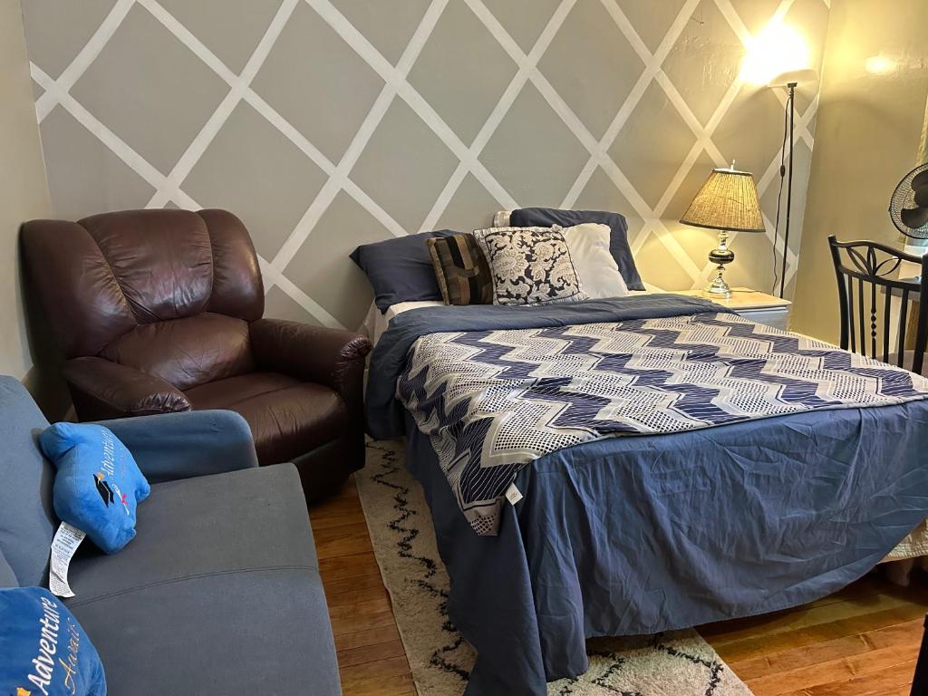 1 dormitorio con 1 cama y 1 silla en Maryland Homestay in Winnpeg downtown en Winnipeg