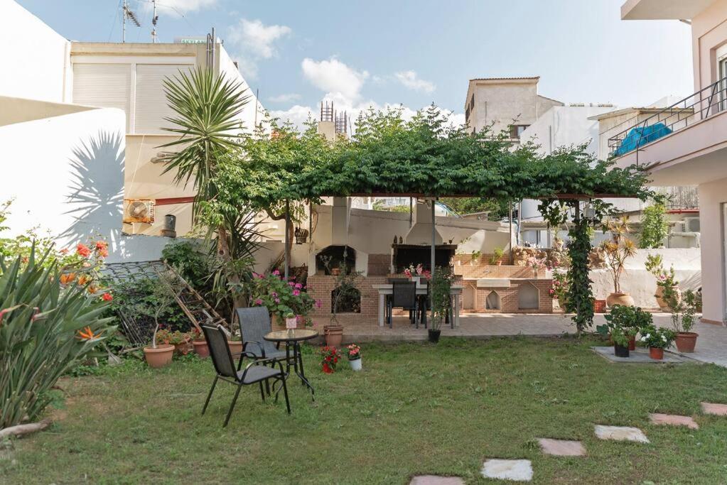 een tuin met een prieel en een tafel en stoelen bij Casa Valore in Chania