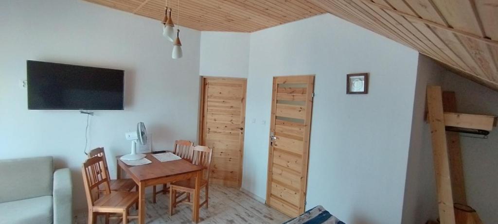 a dining room with a table and a tv and a room at Villa Rosa pokoje u Marzeny in Władysławowo