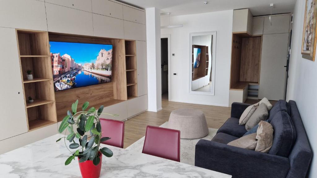 uma sala de estar com um sofá e uma televisão na parede em Valentini Apartments em Cluj-Napoca