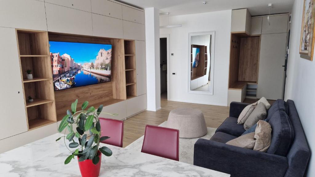 a living room with a couch and a tv on a wall at Valentini Apartments in Cluj-Napoca