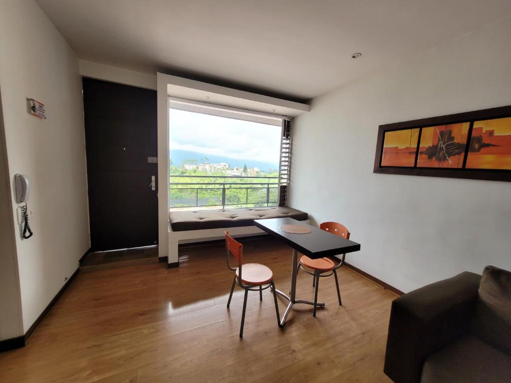 een woonkamer met een tafel en stoelen en een raam bij M402- Apartaestudio tipo loft en el norte (Av 19) in Armenia