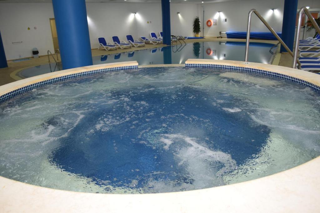a hot tub with blue water in a room at Aktea Beach Village in Ayia Napa