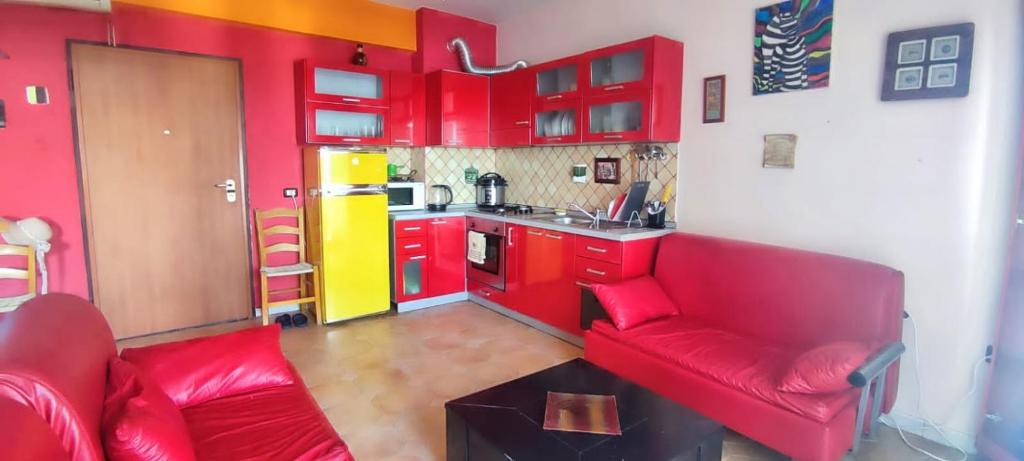uma sala de estar vermelha com um sofá vermelho e uma cozinha em A&K Sea view apartament 7 em Durrës