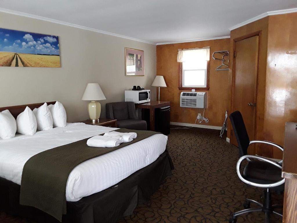 una habitación de hotel con una cama grande y una silla en Gladstone Motel, en Gladstone