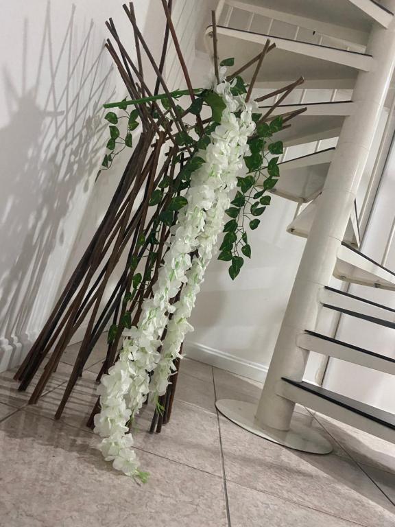 a tall arrangement of white flowers in a stair case at B&B Occhiolà in Grammichele