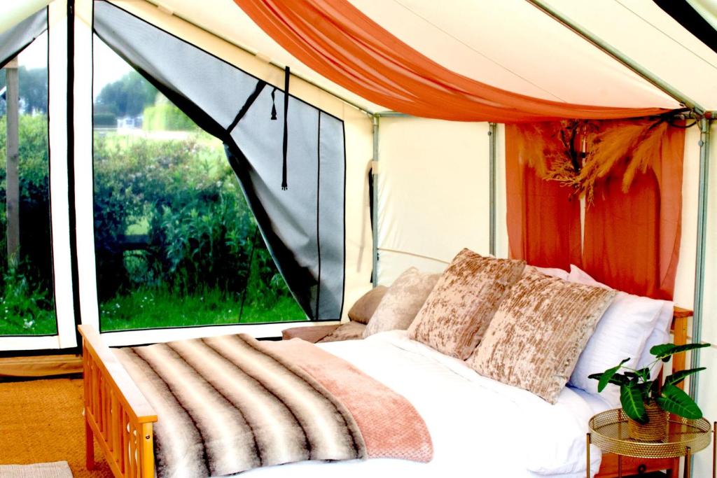 a bed in a room with a large window at Bell Tent Village in Nottingham